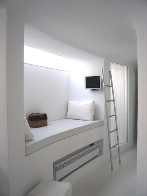 Minimalist alcove bed with under-bed storage and a TV mounted on the wall