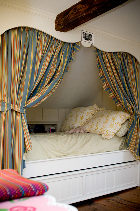 Traditional kids bedroom with a cozy alcove bed featuring built-in storage