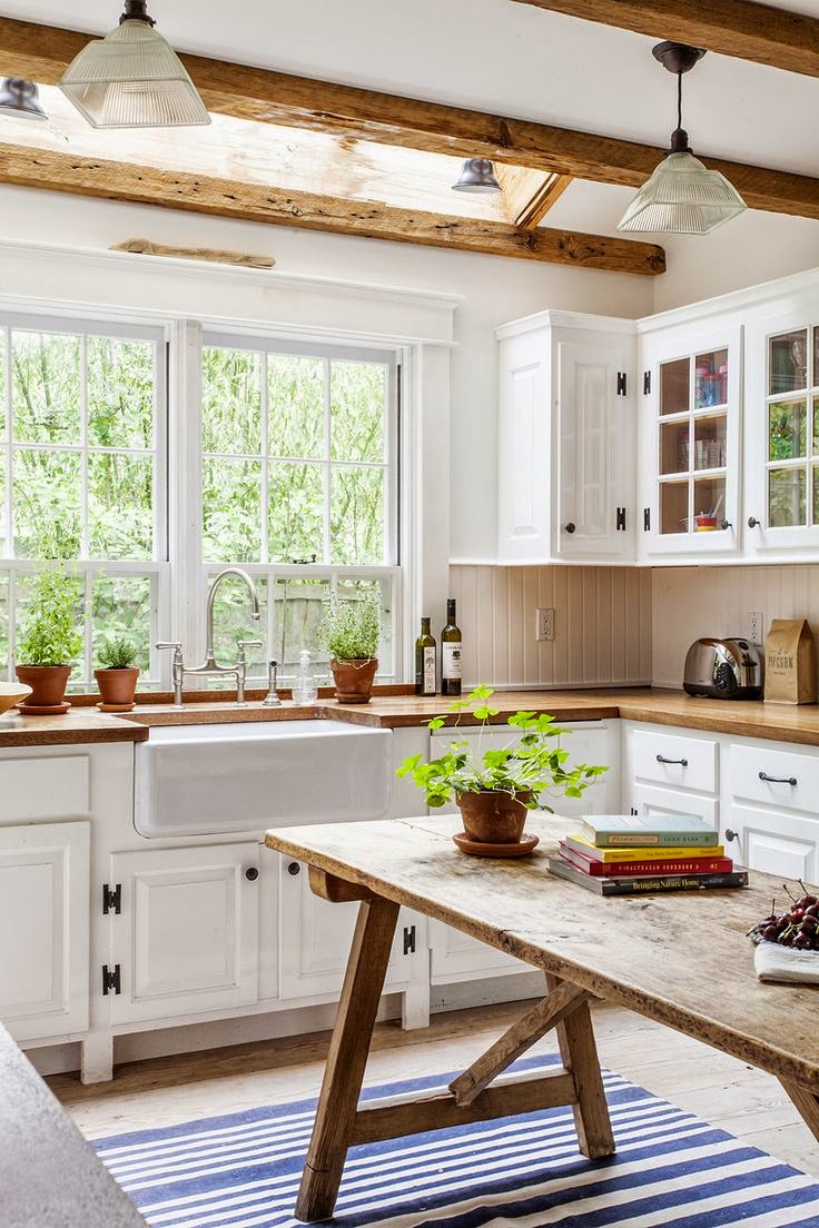 wood table, counters and beams look so good against all the creamy white