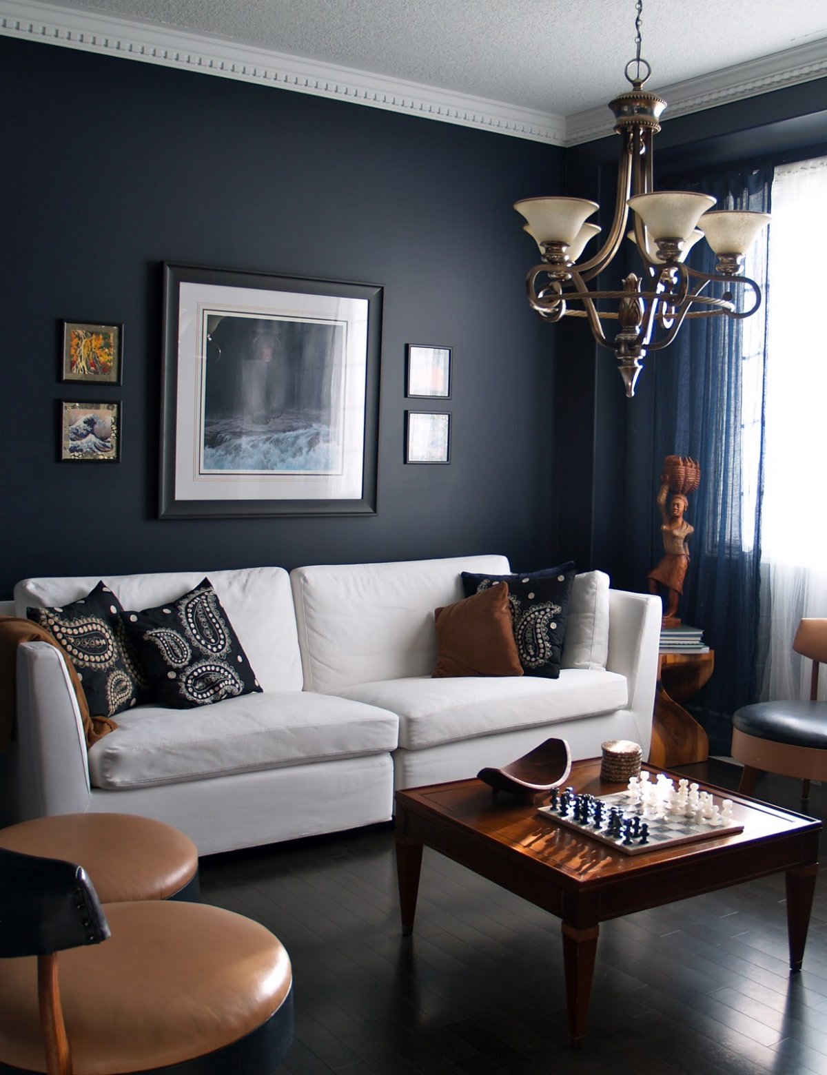 living rooms with dark navy blue walls with white sofa and classic chandelier