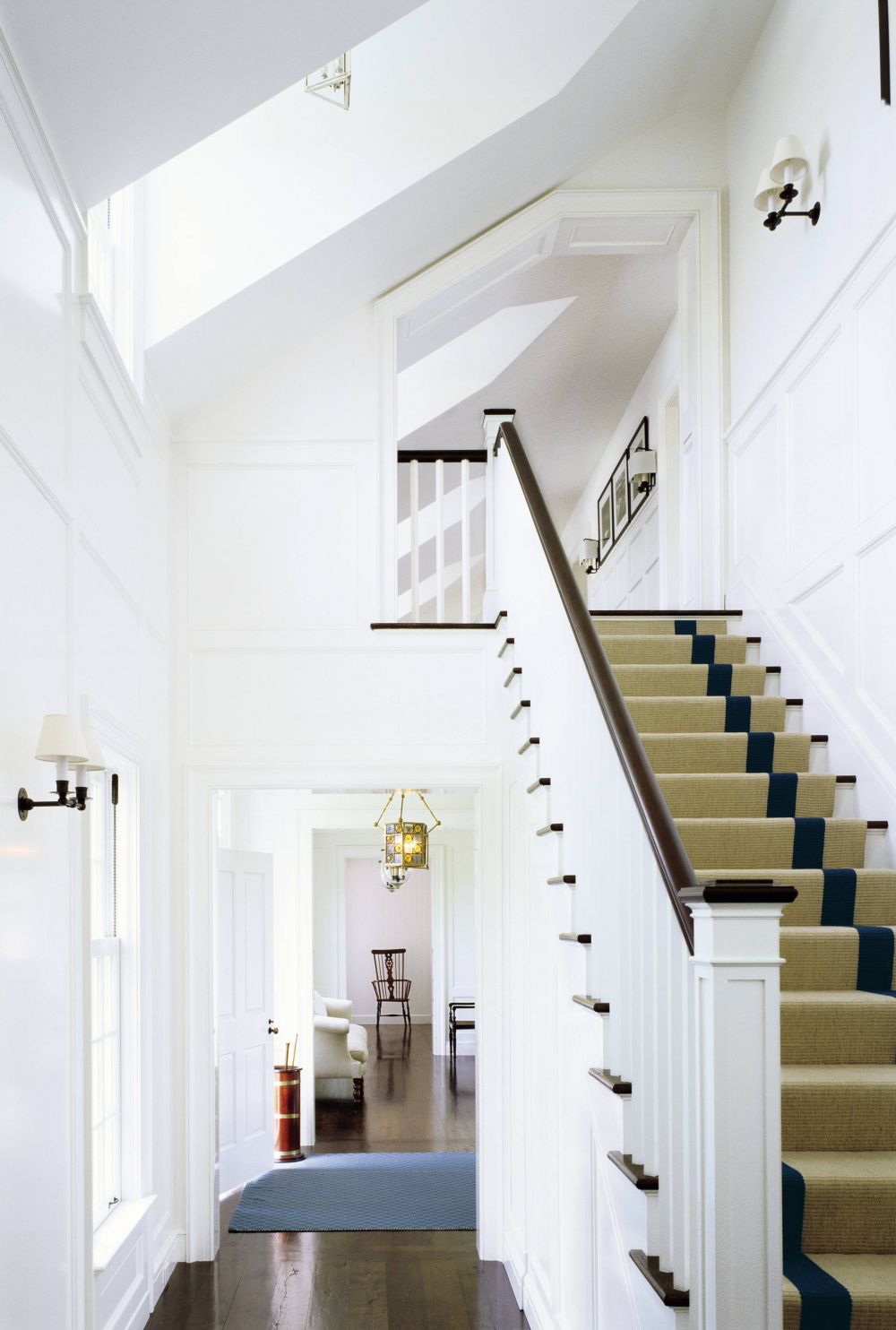 Light floods through dormer windows into the double-height stair hall of an 8000 square foot Nantucket home