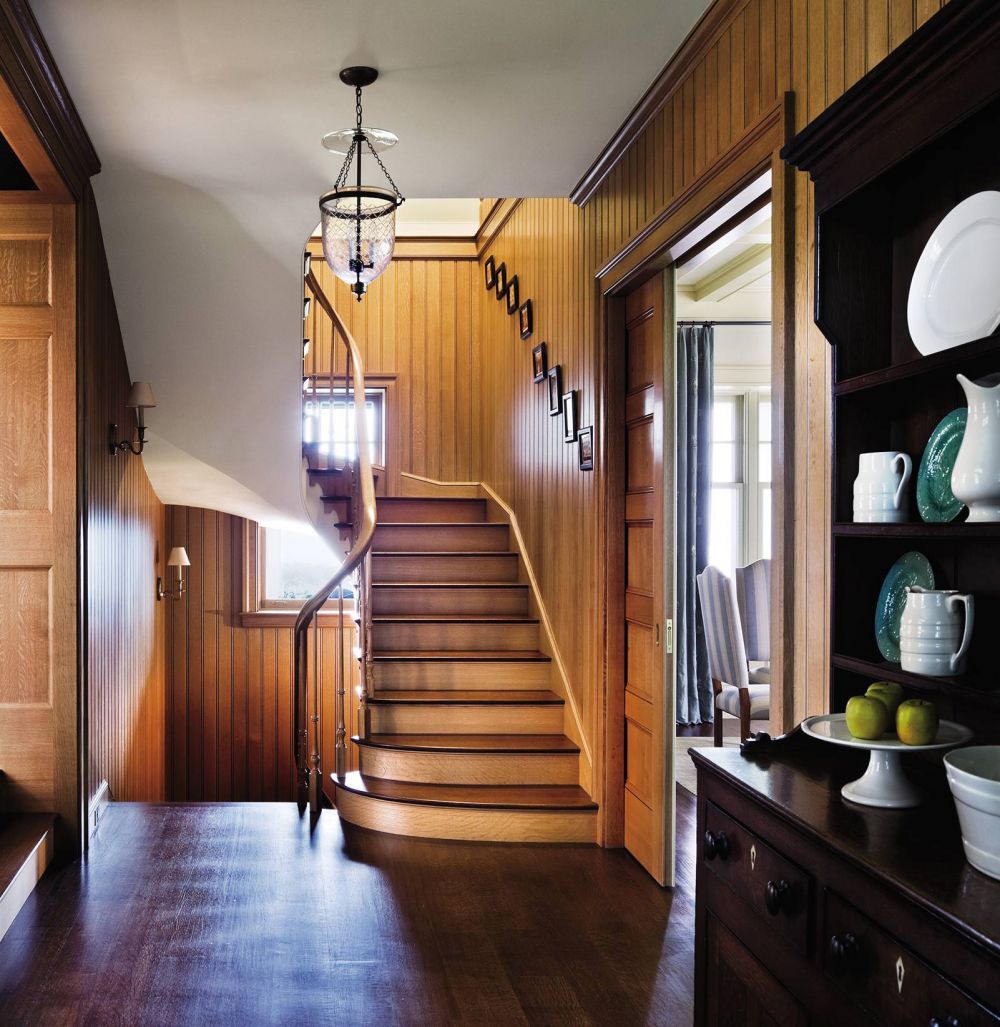 The floor, stairs, and beadboard paneling in the hall