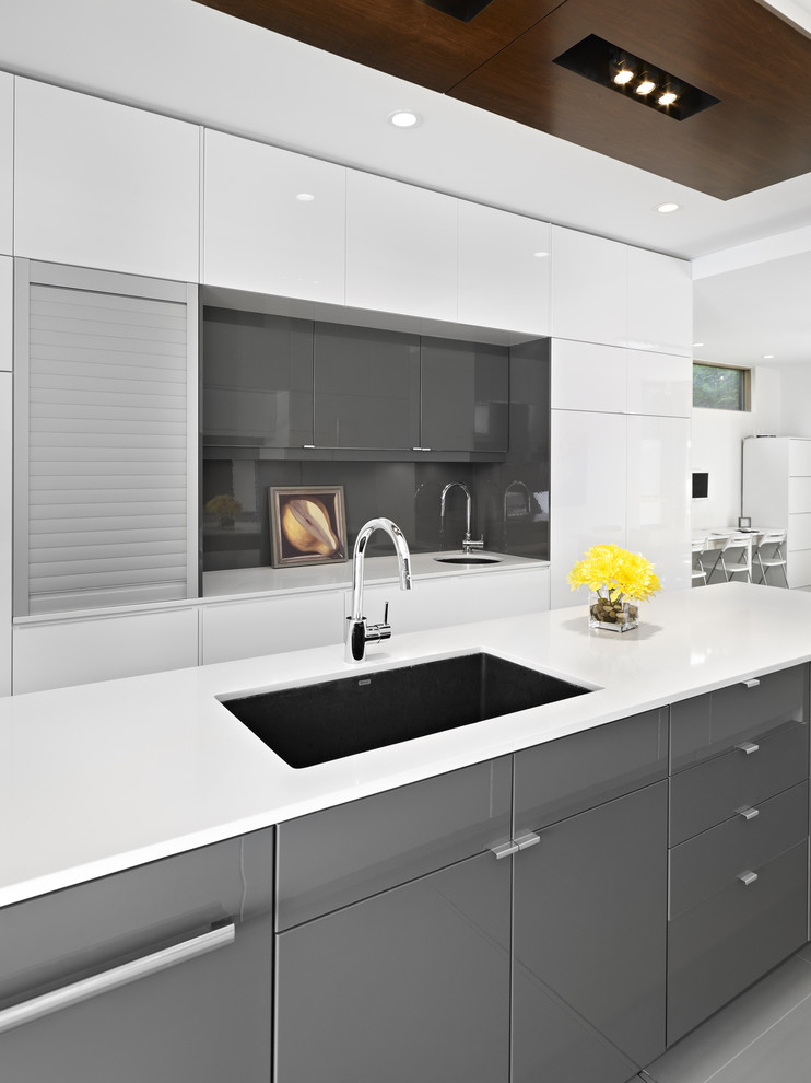 modern kitchen in Edmonton with flat-panel cabinets, gray cabinets, gray backsplash and glass sheet backsplash.