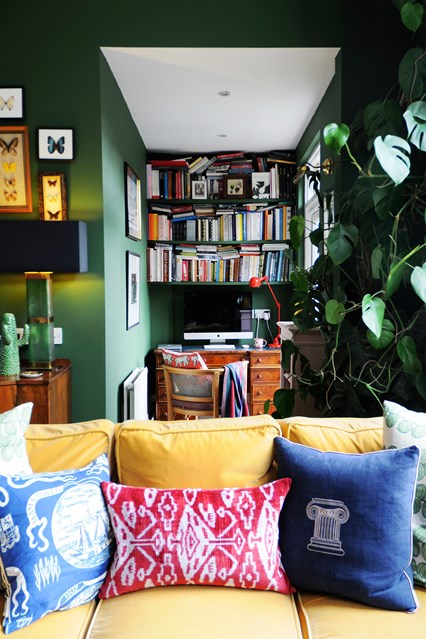 velvet sofa decorated with cushions opposite study nook