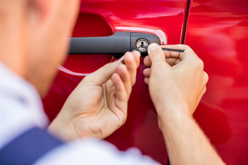 Close-up Of Person’s Hand Opening Car Door With Lockpicker