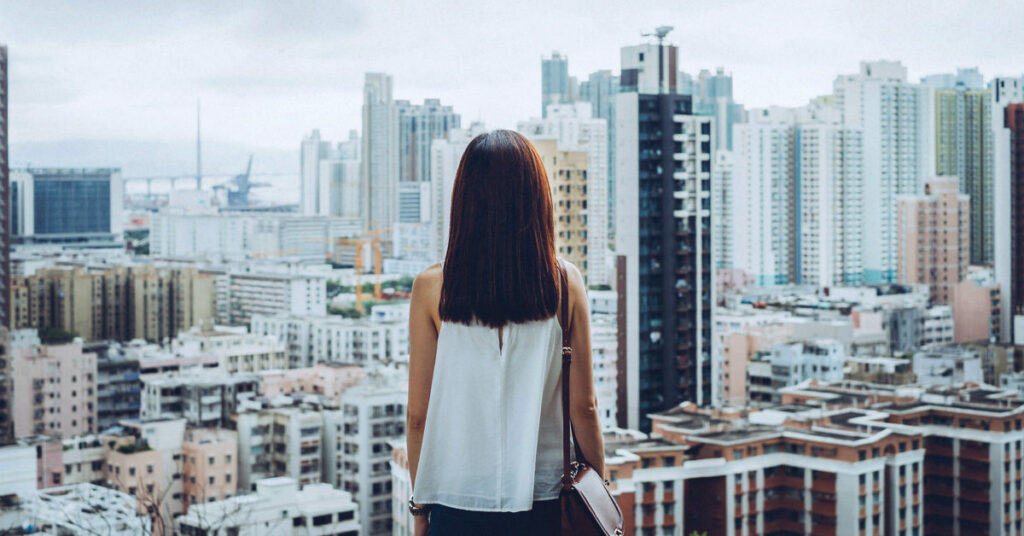 Rear view of woman overlooking busy and energetic cityscape of Hong Kong