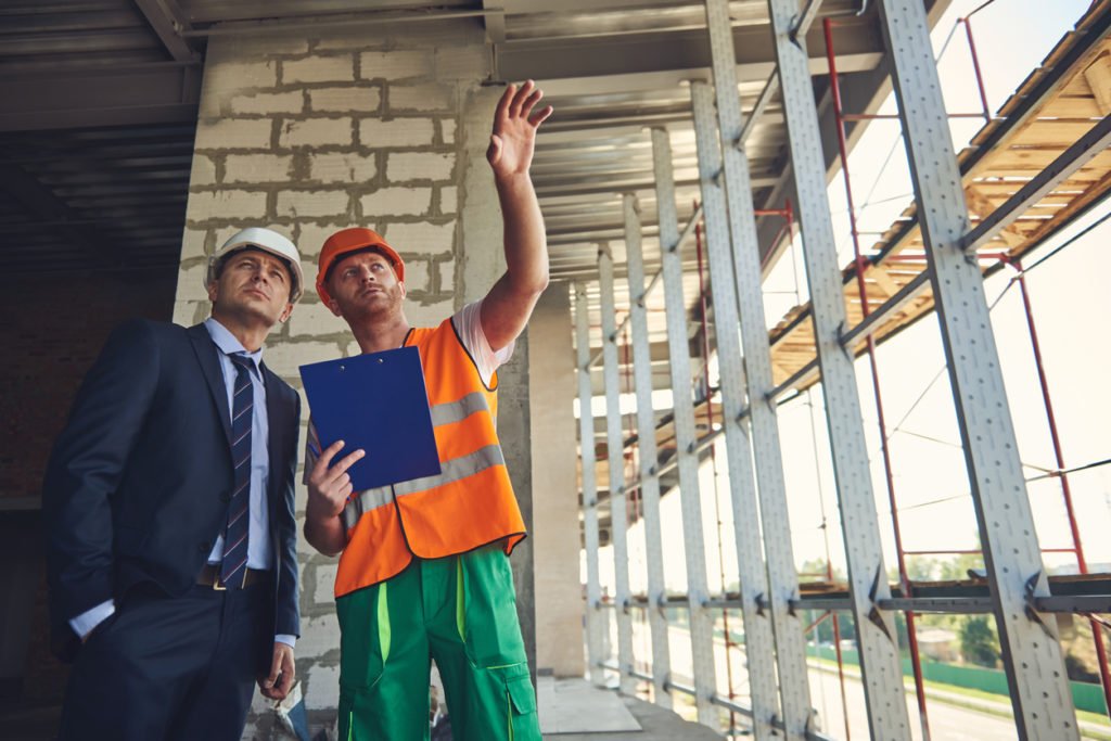 Architect and engineer are looking on building construction